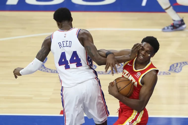 Paul Reed, left, of the SIxers and Brandon Goodwin of the Hawks get tangeled up during the 2nd half of a NBA game at the Wells Fargo Center on April 28, 2021.