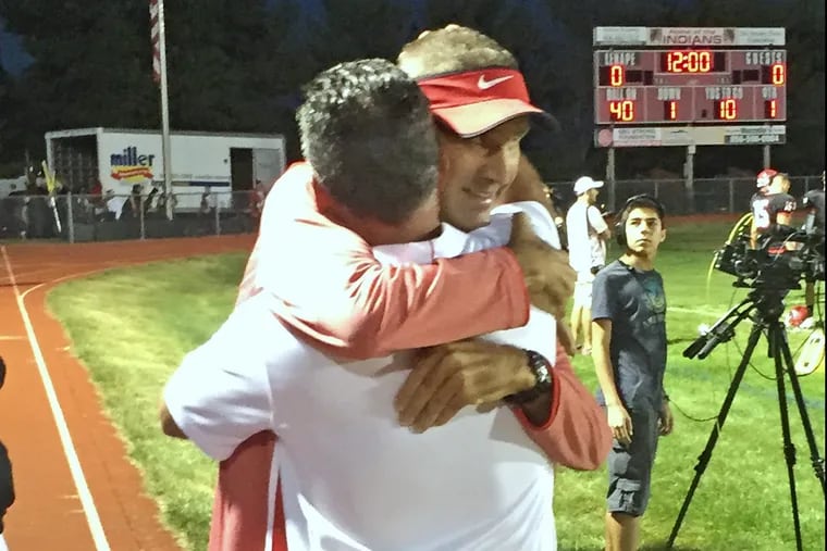 Lenape assistant coach Mark Lilley (with visor) embraces Lenape head coach Tim McAneney before game in 2017. Lilley died Tuesday after long battle with colon cancer.