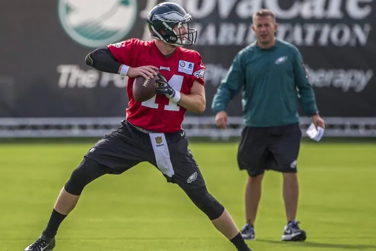 Eagles quarterback Carson Wentz  works through drill under the watchful eye of quarterbacks coach, John DeFilippo on Monday.