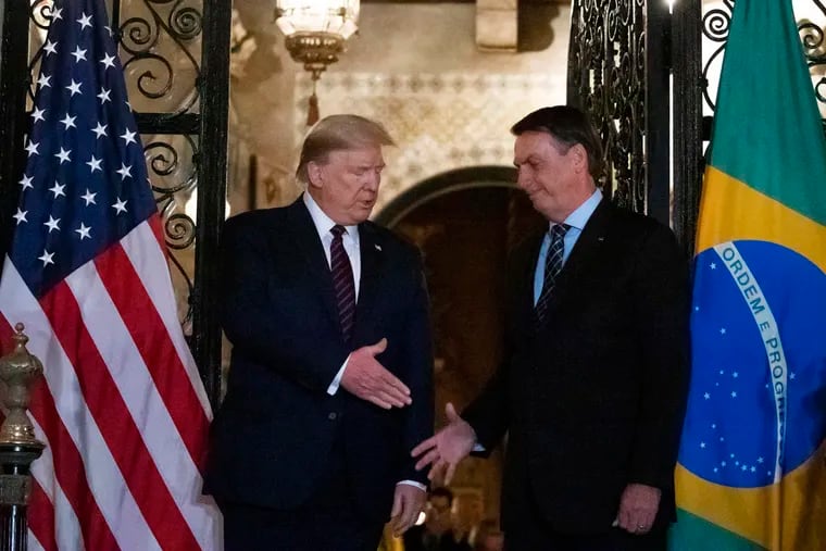 President Donald Trump shakes hands before a dinner with Brazilian President Jair Bolsonaro on March 7 at Mar-a-Lago in Palm Beach, Fla.