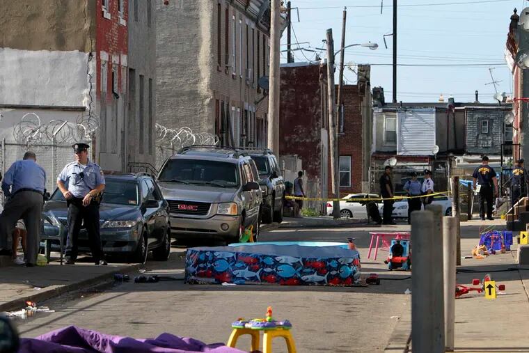 Investigators process the crime scene on the 3200 block of N. Randolph Street in North Philadelphia, Sunday June 15, 2014, after two men were wounded by gunfire, one of them by an officer police said.(For the Daily News/ Joseph Kaczmarek)