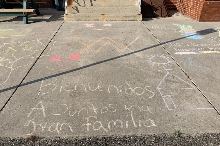 Chalk drawings in Spanish - Bienvenidos a Juntos, una gran familia - form a welcome at the entrance to the Juntos shelter in Northfield, Atlantic County, serving unaccompanied children who have crossed the Southern border. The shelter is on county property that is leased to the Center for Family Services, a Camden-based non-profit, which is expanding this program.