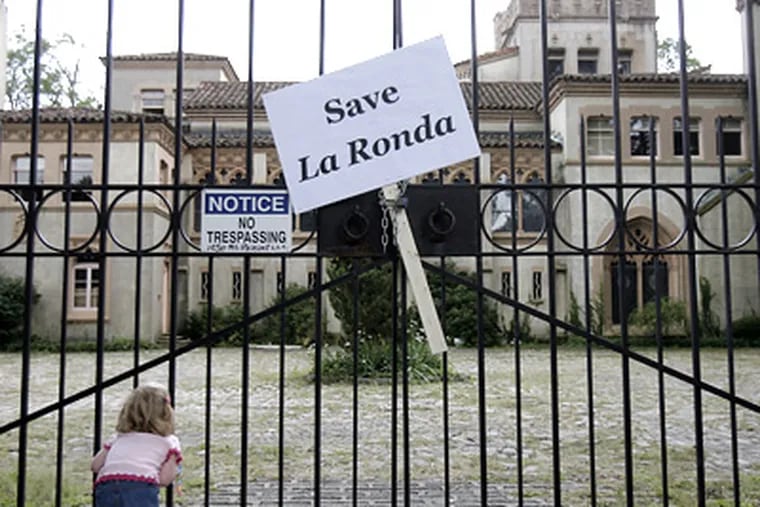 Devon Mattox, 4, of Havertown, views La Ronda through its fence, next to a “Save La Ronda” sign. (Akira Suwa / Staff Photographer)