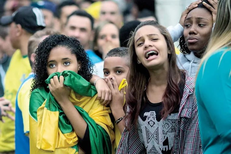 Brazil soccer fans watch their team lose to Germany at a World Cup semifinal game on TV in Sao Paulo, Brazil, Tuesday, July 8, 2014. (AP Photo/Rodrigo Abd)