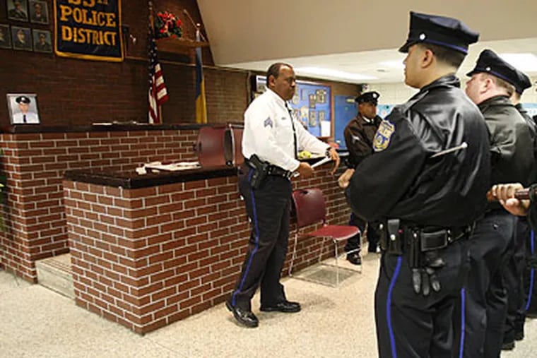 Sgt. Herbie Gibbons, left, at roll call. A photograph of fallen police officer John Pawlowski, at far left,  on a ledge in a makeshift courtroom inside the police station. (David Maialetti / Staff Photographer)