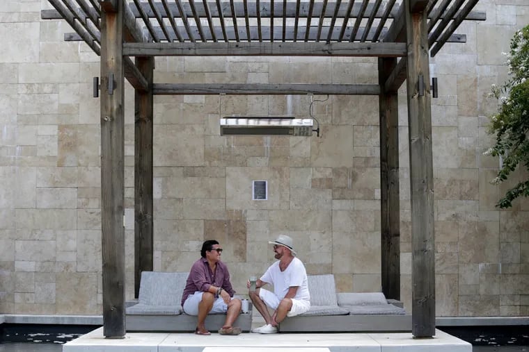 Traviss Kraisoraphong (left) and his partner Michel Noel relax in the pool area at Presidential City in Philadelphia. "The grounds are amazing," Noel said.