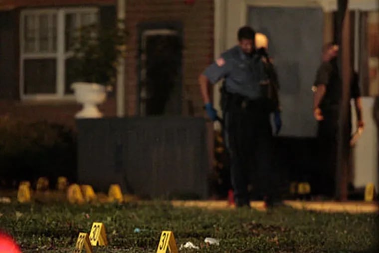 Evidence markers dot the lawn in front of the Arborwood Complex in Lindenwold  where 6 people were shot on Sept 6 2009. ( Elizabeth Robertson / Staff Photographer )