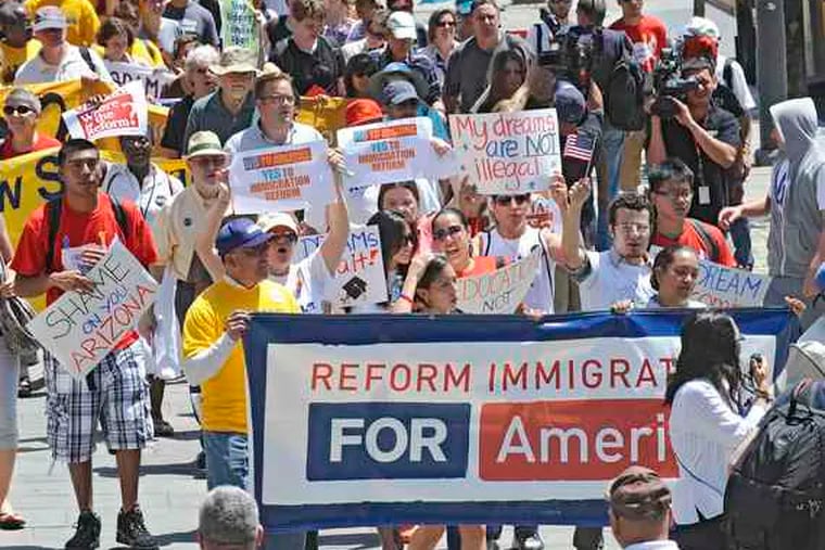 Protesters march up Market Street to Independence Mall in the &quot;From Philly to Phoenix&quot; rally Wednesday. They denounced Arizona's crackdown on illegal immigration and called on President Obama to honor his campaign pledge to bring about comprehensive reform. B7.