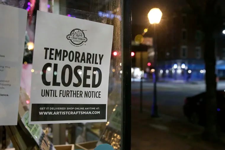 A sign in the window of the Artist and Craftsman Supply alerts folks that they are closed until further notice.