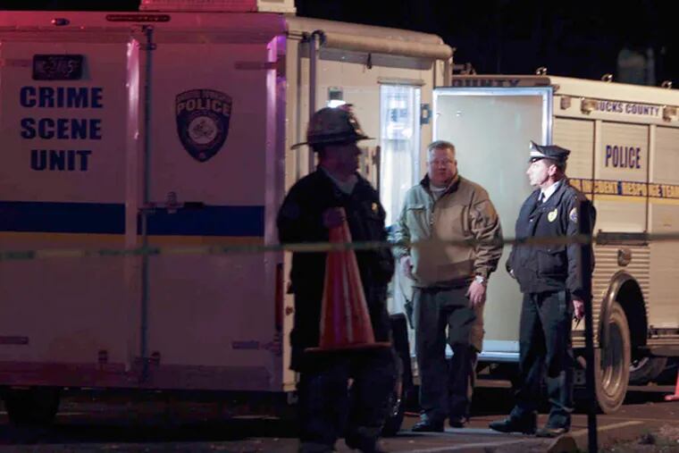 Investigators gather outside the Avalon Court apartments in Bucks County. Six residents were displaced by the search into the cause of two deaths. JOSEPH KACZMAREK /For the Inquirer