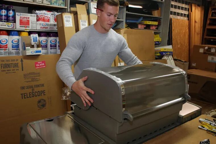 Matt Lichtenstein has been building gas grills at Wallace’s Hardware in Ocean City, N.J., for the last week in preparation for Memorial Day weekend, start of the summer season. (TOM BRIGLIA / For The Inquirer)