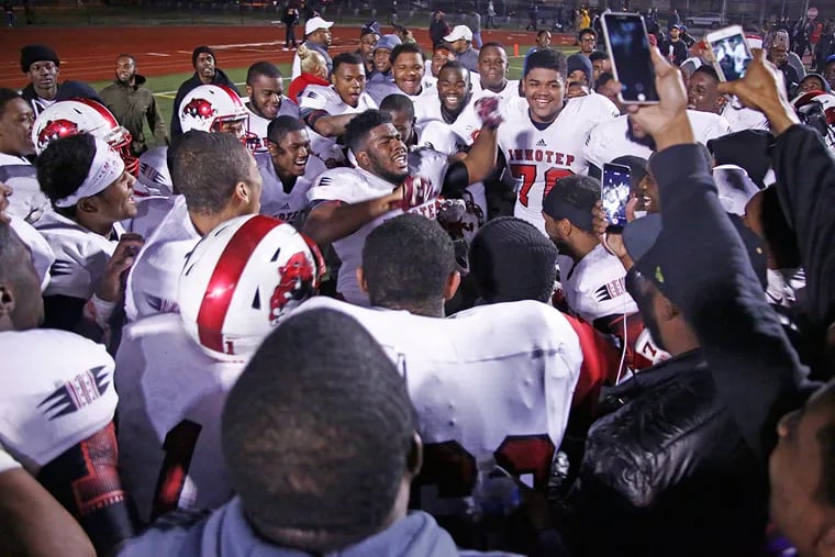 Imhotep Charter players huddle in celebration around tight end Naseir Upshur (arms raised) after their championship victory over Archbishop Wood. Imhotep won, 20-14, Saturday (11/28/15) in the District 12 Class AAA football final at Northeast High. (LOU RABITO / Staff)