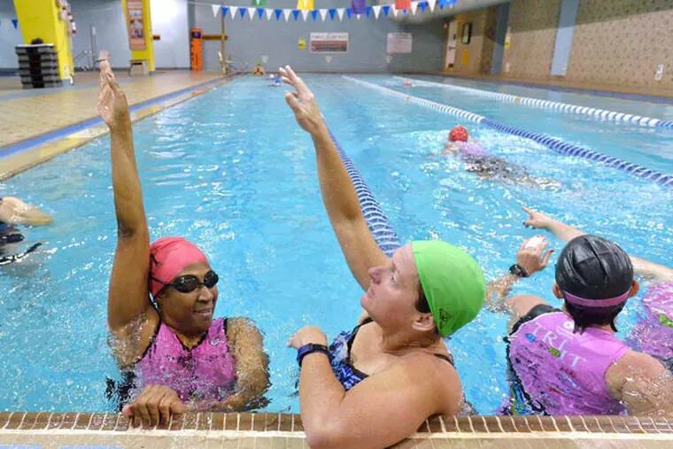 Try It For Life athlete Pam Christian, left, gets help with her backstroke from Try It For Life mentor Lisa McDaniel during a swim lesson on May 15,2014 at the Dowd YMCA in Charlotte, N.C. (Robert Lahser/Charlotte Observer/MCT)