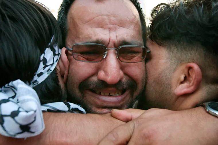 Relatives hug a freed inmate in the West Bank. Palestinians view the releases as a test of Israel&#0039;s willingness to make peace.