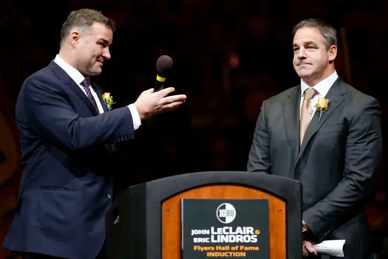 Eric Lindros (left) acknowledging former teammate John LeClair during a Flyers Hall of Fame ceremony in 2014. LeClair will coach in a new three-on-three league next year.