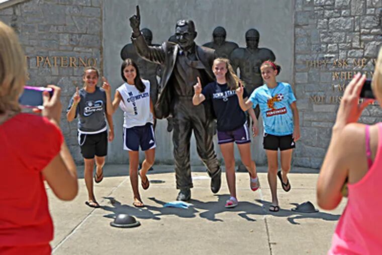 At the Paterno statue, Sue Wilke (left) and Kaila Wilke photograph (from left) Jordan Williams, Maggie Mastrogiacomo, Gianna Wilkes, and Megan Schmittinger in the "We're No. 1" pose. (Michael Bryant / Staff Photographer)