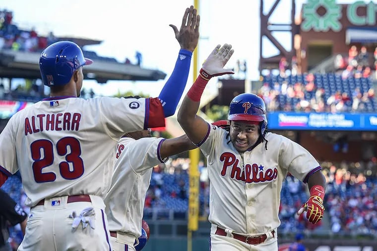 Phillies third baseman Maikel Franco gets high-fives from Aaron Altherr and Nick Williams after hitting a three-run homer in the season finale Sunday.