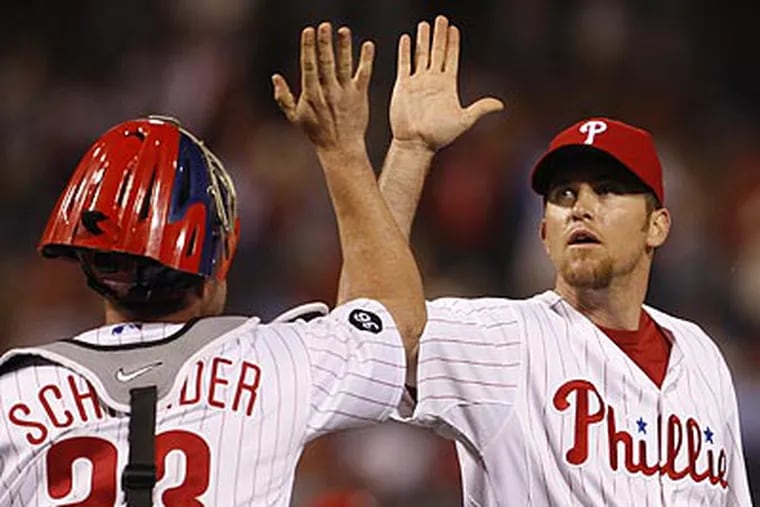 Brad Lidge high fives Brian Schneider after closing out the ninth in Friday's 9-5 win. (Ron Cortes / Staff Photographer)