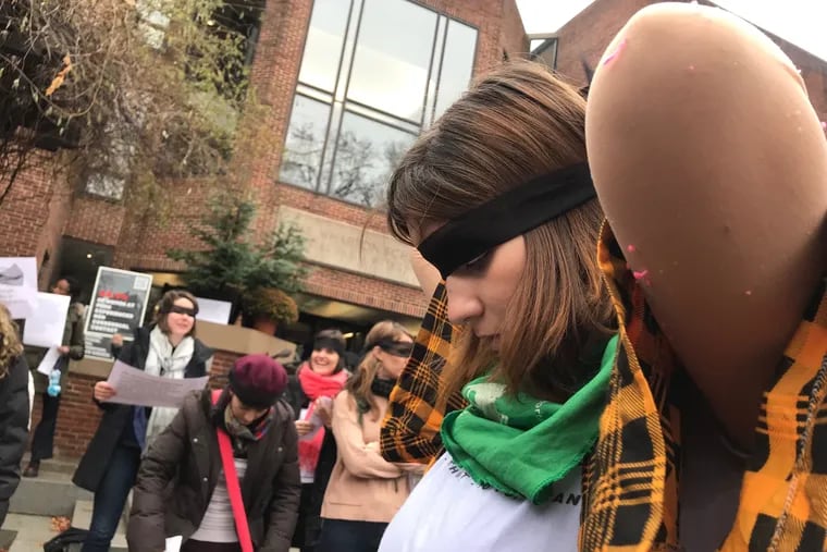La estudiante de Ciencias Políticas Selene Bonczok Sotelo, de 21 años, se coloca una benda de malla negra alrededor de sus ojos antes de realizar el performance "Un violador en tu camino" en Penn el lunes 9 de diciembre de 2019.
