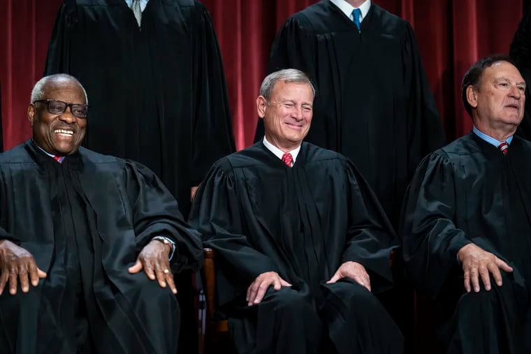 Members of the U.S. Supreme Court (from left) Justice Clarence Thomas, Chief Justice John G. Roberts Jr. and Justice Samuel A. Alito Jr. share a laugh during a portrait session for the court in October.