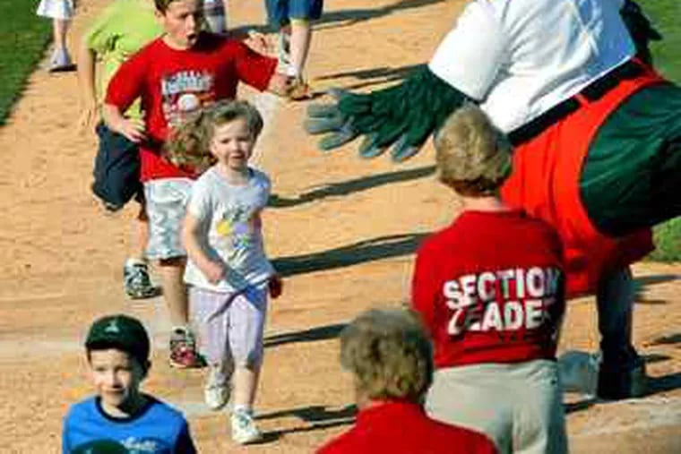 Lou E. Loon, mascot to the Great Lakes Loons, greets children at home plate after a game at Dow Diamond in Midland.