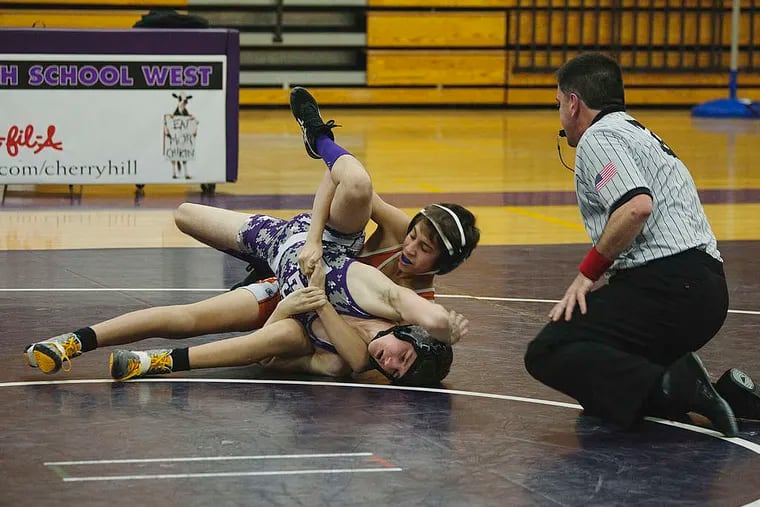 Cherry Hill West's Patrick Bean (rear) grapples with Cherokee's Jacob Schoch in the 106-pound bout. Schoch scored an 18-3 technical fall during Cherry Hill West's 38-33 victory. CHRIS FASCENELLI / Staff Photographer