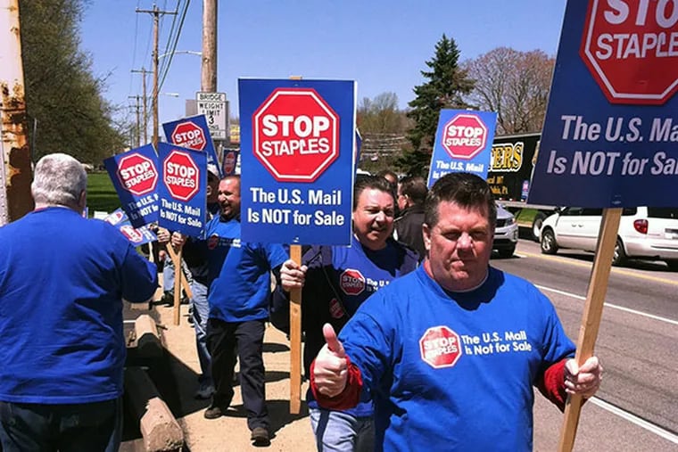 Ron Dever, a postal worker for 27 years, joins his American Postal Workers Union colleagues to protest the U.S. Postal Service plan to open 1,500 mini stations in Staples stores with non-union staff. (DAN GERINGER/Daily News Staff)