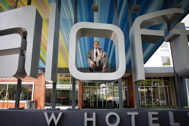 Aloft General Manager Patrick Sanchez is photographed in the logo in front of the new hotel. (DAVID SWANSON / Inquirer)