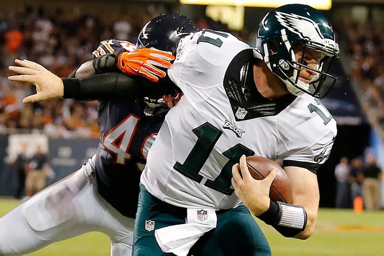 Carson Wentz is tackled by a Bears defender.