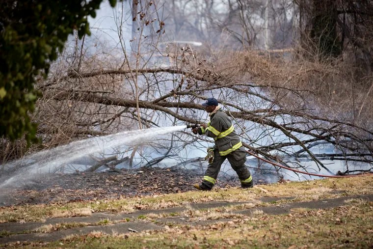 Philadelphia Fire Department firefighters working to extinguish a small brush fire off Sweetbriar Lane in Fairmount Park in March. This is the peak wildfire season.
