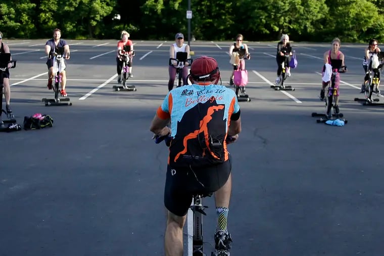 Cycling instructor Tom Hambrose (foreground) leads the 45 minute “Cycling with Tom” spin class in the parking lot at Royal Fitness in Barrington, N.J. on May 27, 2020.