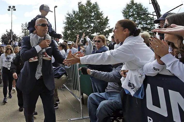 Penn State head coach James Franklin, carrying fan Josiah Viera, 13, greet fans as the team arrives at the stadium to take on Pittsburgh in an NCAA college football game in State College, Pa., Saturday, Sept. 9, 2017. Josiah, suffers from a genetic disease called Progeria, meaning “prematurely old”.