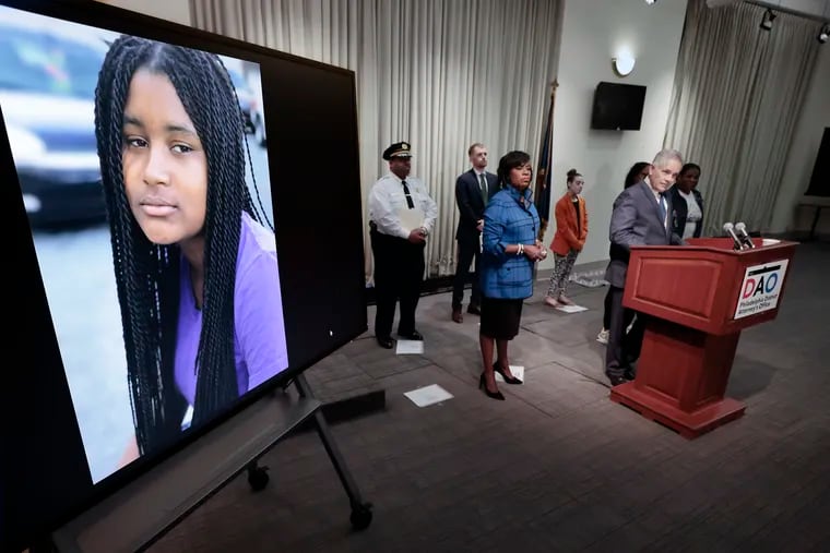 A photo of Sandrea Williams, 17, of West Philadelphia (left) is displayed as First Deputy Commissioner John Stanford, Assistant District Attorney Jeffrey Palmer, Mayor Cherelle L. Parker and District Attorney Larry Krasner (at podium) hold a press conference announcing that law enforcement has identified two men they say shot and killed 17-year-old Sandrea Williams in May 2018 -- a shooting that prosecutors say ignited what would become a years-long feud between two West Philadelphia gangs and lead to more gunfire.