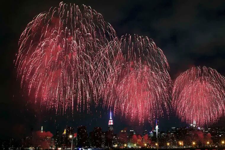 With the Manhattan skyline as a backdrop, fireworks light up the sky over the East River during the Macy's Fourth of July display. This is the view from Brooklyn.