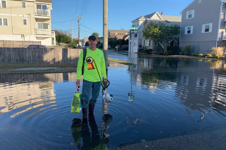 Clint Hunter, who lives in Ventnor Heights, wading out through the water on Edgewater Street to get to a landscaping job during Melissa-related floods.