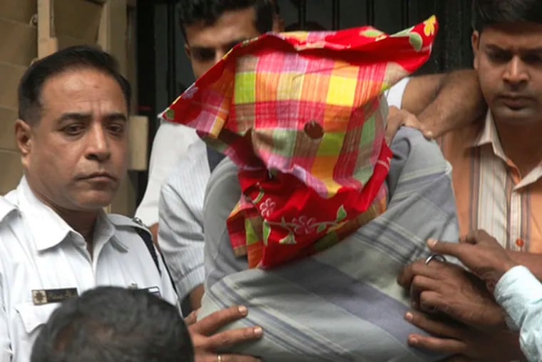 Police escort a man identified as Mukhtar Ahmed to court in Calcutta, charged in connection with the Mumbai attacks. But police in Indian Kashmir say he was working for them.