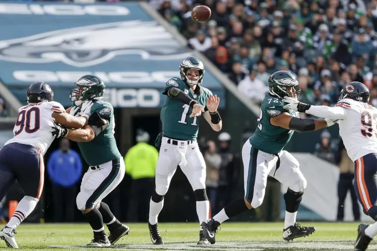 Eagles quarterback Carson Wentz throws a first-quarter pass as offensive linemen Stefen Wisniewski and Halapoulivaati Vaitai block Chicago Bears defensive end Jonathan Bullard (left) and outside linebacker Sam Acho (right) on Sunday.