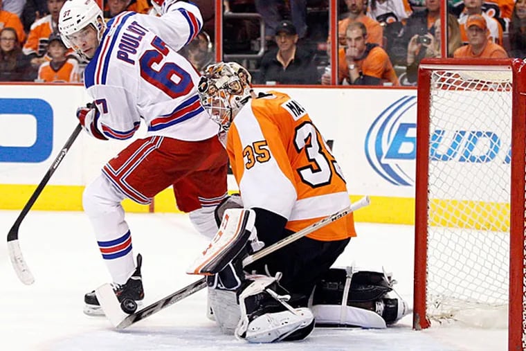 Steve Mason, right, stops the puck with his stick as New York Rangers' Benoit Pouliot, left, looks back for it during the second period in Game 4 of an NHL hockey first-round playoff series on Friday, April 25, 2014, in Philadelphia. (Chris Szagola/AP)