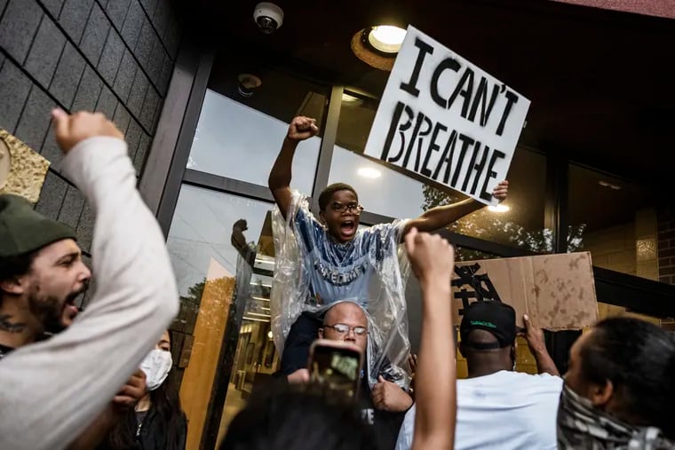 People gathered at a police precinct during a protest for George Floyd in Minneapolis on Tuesday.