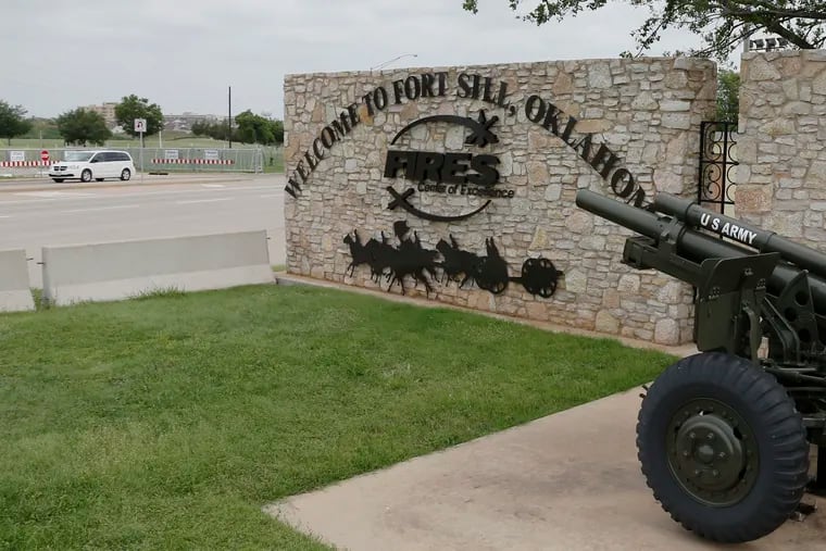 In this June 17, 2014 file photo, a vehicle drives by a sign at Scott Gate, one of the entrances to Fort Sill, in Fort Sill, Okla. The federal government has chosen Fort Sill, a military base in Oklahoma, as the location for a new temporary shelter to house migrant children.