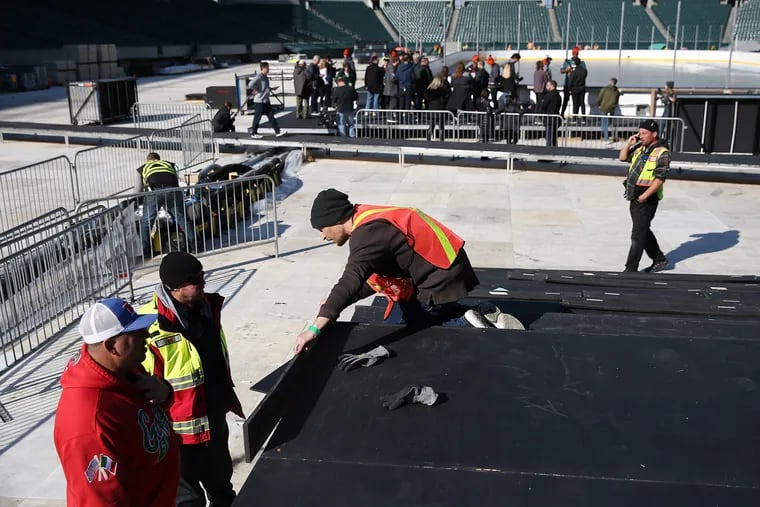 Workers preparing Lincoln Financial Field for the Stadium Series game.