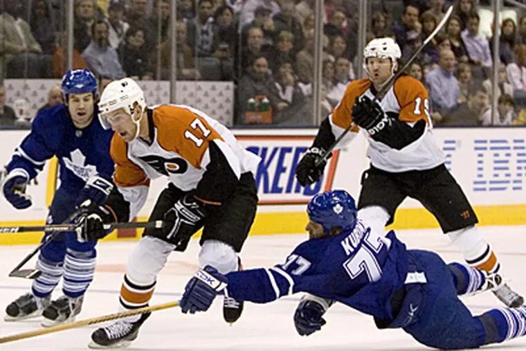 The Maple Leafs' Pavel Kubina (right) stretches to deny the Flyers' Jeff Carter as Maple Leafs' defenseman Jeff Finger (left) and Flyers' Scott Hartnell follow the play during Saturday's game in Toronto . (AP Photo/The Canadian Press, Chris Young)