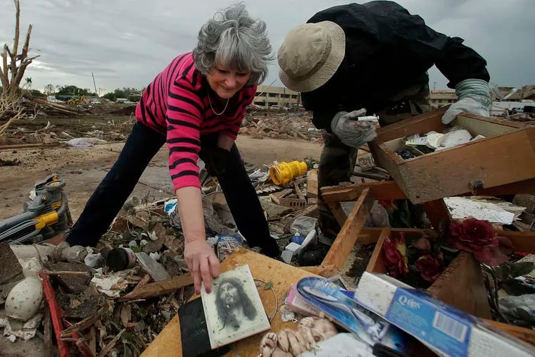 Lea Bessinger salvages a picture of Jesus as she and son Josh sort through the rubble of her home. Oklahoma Gov. Mary Fallin lamented the loss of life, but said: &quot;We will rebuild, and we will regain our strength.&quot;