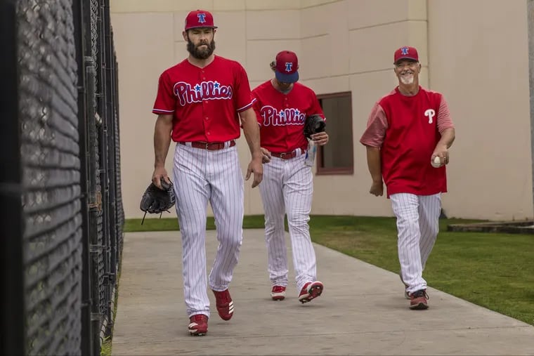 Phillies pitching coach Rick Kranitz, right, walks with Jake Arrieta, left, and Aaron Nola during spring training in Clearwater, Fla.