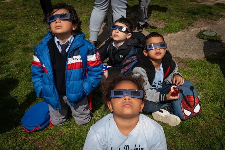 Students at the Antonia Pantoja Charter School watch the eclipse, in Philadelphia, Monday April, 8, 2024.