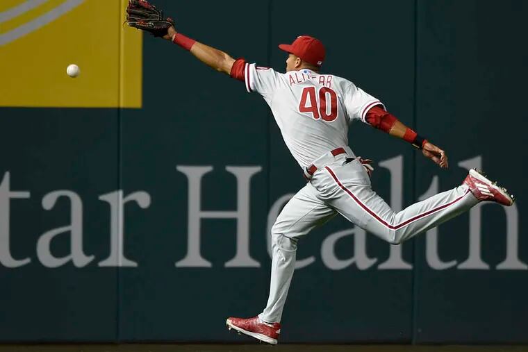 Aaron Altherr misses catching a ball hit by the Nationals' Anthony Rendon, who got a double in the first inning. Altherr had two home runs and five RBIs.