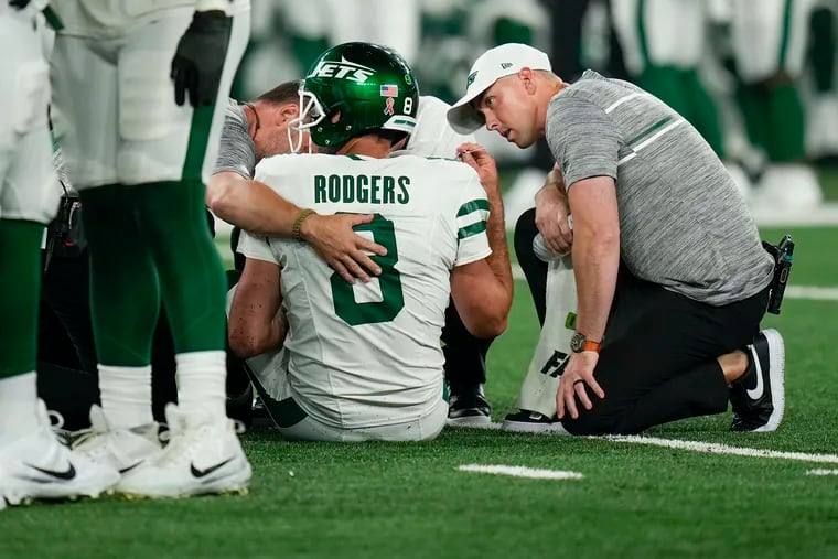 New York Jets quarterback Aaron Rodgers is tended to on the field after suffering a season-ending injury against the Buffalo Bills on Sept. 11.
