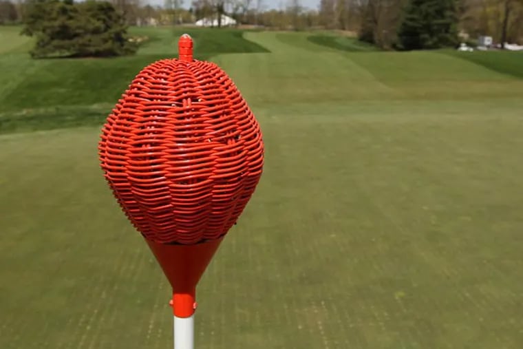 Most golf clubs use flags on their greens to give players a target. Merion uses wicker baskets atop its golf poles. (Michael Bryant/Staff Photographer)