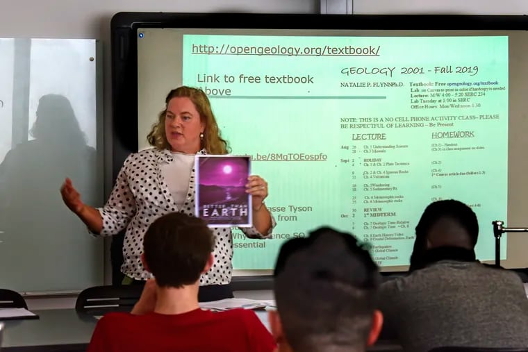 Temple University physical geology professor Natalie Flynn talks to her students about using a free website (on smart board) instead of a textbook, on the  first day of class Aug. 26, 2019. She is using open resource materials in the classroom as part of a program at Temple that encourages professors to write their own textbooks or use other free resources so students don't have to buy expensive textbooks.