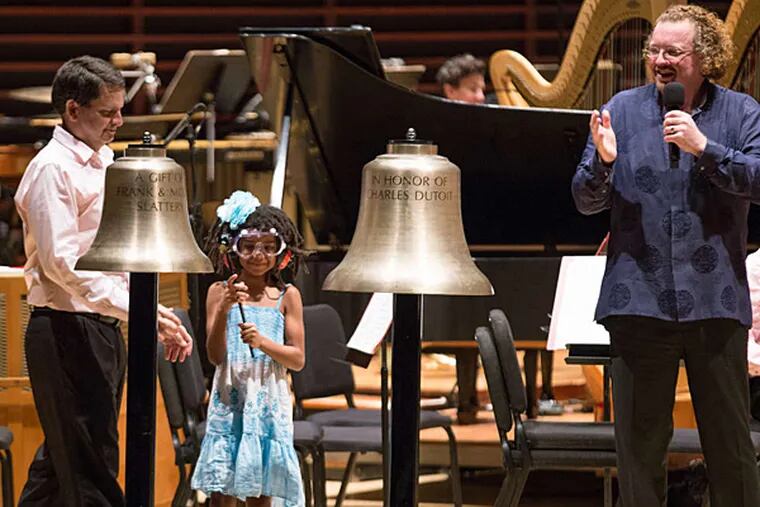 Conductor St&#0233;phane Den&#0232;ve (right) has audience members ring bells during the Philadelphia Orchestra's &quot;neighborhood concert&quot; at the Kimmel Center's Verizon Hall. (Philadelphia Orchestra Association)